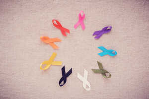 A variety of colourful awareness ribbons arranged in a circle