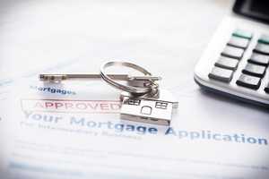 Approved mortgage application with house shaped keyring and calculator