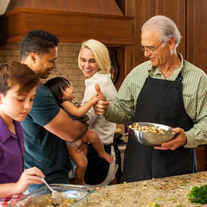 3 generation family preparing dinner in a kitchen