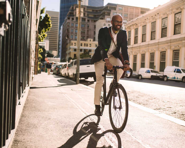 man riding a bike in a city to work