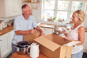Senior couple packing boxes in the kitchen before moving home