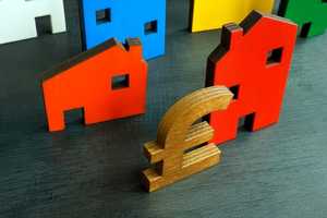 Colourful wooden models of houses with pound sign