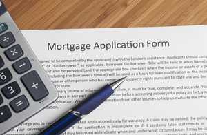 Mortgage application form with a calculator and a pen