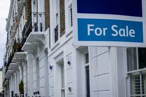 Estate agent 'for sale' sign outside a smart London terrace