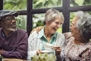 Three older people enjoying afternoon tea