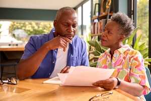 Older couple sitting at kitchen table reviewing finances