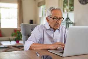 Senior man working on a laptop at home